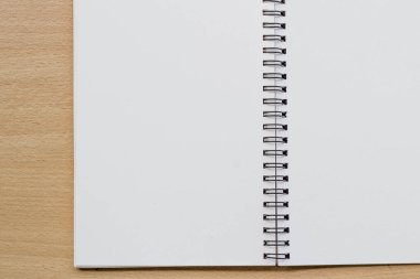 Tahta masanın üzerinde boş spiral defter açıldı