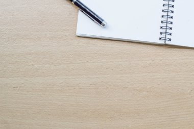 Tahta masanın üzerinde boş spiral defter açıldı