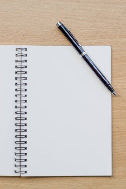 Tahta masanın üzerinde boş spiral defter açıldı