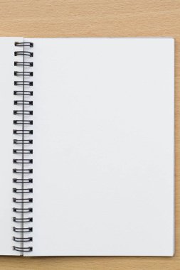 Tahta masanın üzerinde boş spiral defter açıldı