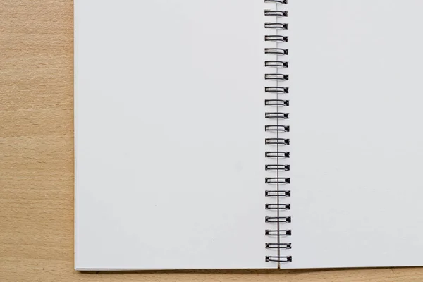 opened spiral blank notebook on wood table