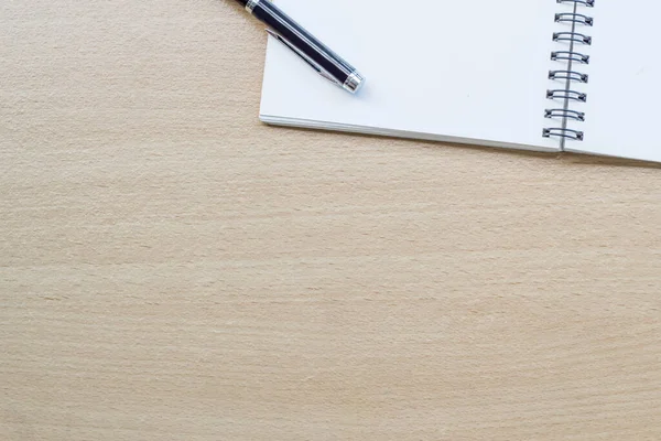 Tahta masanın üzerinde boş spiral defter açıldı