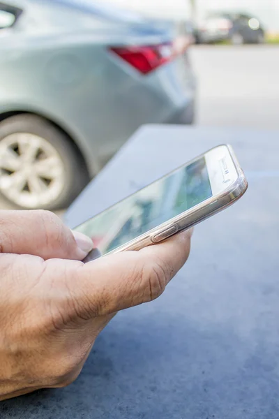 bir akıllı telefon tutarak bir adamın elini