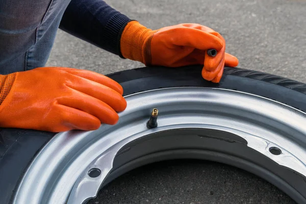 Närbild Kvinna Orange Handskar Håller Bröstvårtan Locket Bilens Hjul — Stockfoto