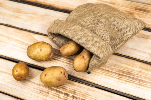 Patatas Frescas Una Bolsa Vieja Sobre Fondo Madera Espacio Libre —  Fotos de Stock