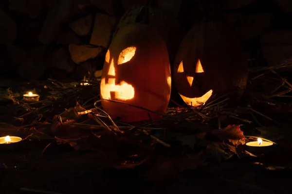 Két Izzó Tök Halloween Éjszaka Háttérben Tűzifa Szénában Gyertyákkal — Stock Fotó