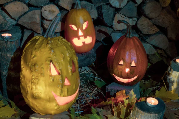 Trzy Pomarańczowe Świecące Dynie Halloween Tle Ułożonego Drewna Opałowego Sianem — Zdjęcie stockowe