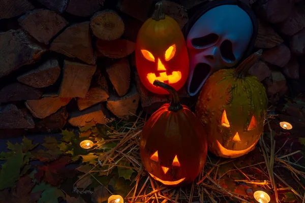 Three Glowing Pumpkins Scream Mask Halloween Night Candles Background Firewood — Stock Photo, Image