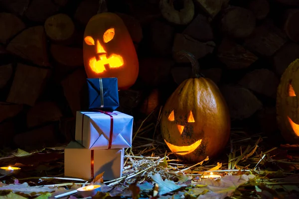 Két Izzó Tök Ajándékok Halloween Este Gyertyákkal Háttérben Tűzifa Őszi — Stock Fotó