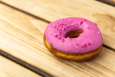 Ahşap arka planda pembe çörek. Metin için boş alan. Çörek Günü