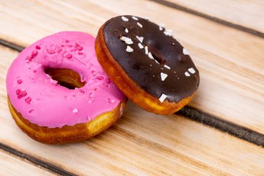 Ahşap arka planda iki ahududu ve çikolatalı çörek. Metin için boş alan. Dünya Donut Günü