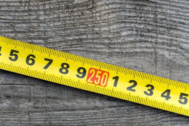 Tahtanın arka planında eski mezura var. Ögeler ölçülüyor