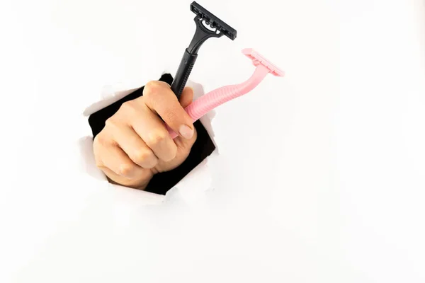 Two Razors Woman Hand Hand Goes Hole White Paper Wall — Stock Photo, Image