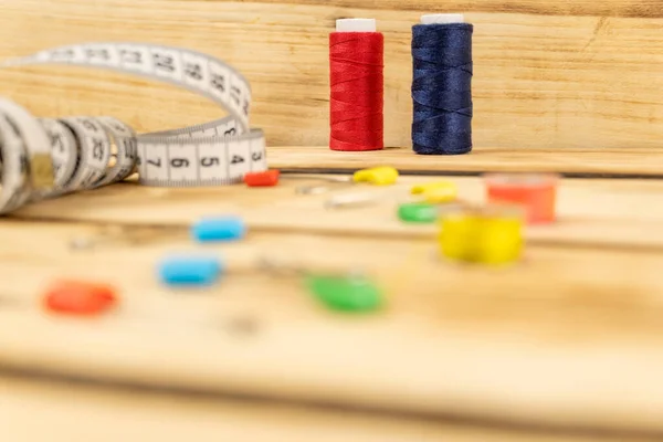 Sewing threads and other sewing accessories on a wooden table. Cutting and sewing concept.