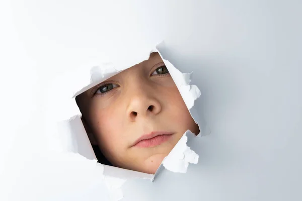 Der Junge Blickt Durch Ein Loch Der Weißen Wand Freiraum — Stockfoto