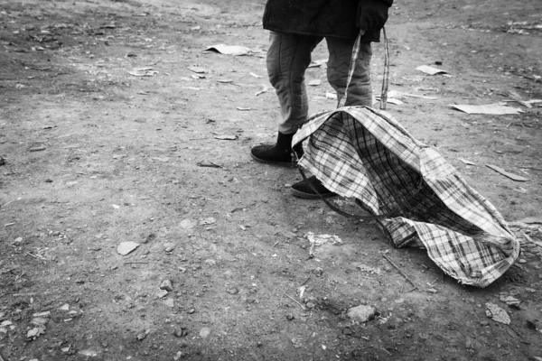 Frauenbeine Zerrissenen Stiefeln Und Mit Einer Zerrissenen Karierten Tasche Vor — Stockfoto