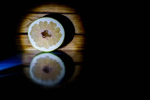 Pomelo Fruta Escuro Contra Fundo Placas Iluminadas Por Uma Luz — Fotografia de Stock