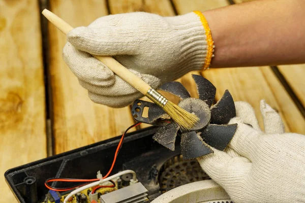 Master Pulisce Ventilatore Della Stufa Elettrica Uno Sfondo Legno Mani — Foto Stock