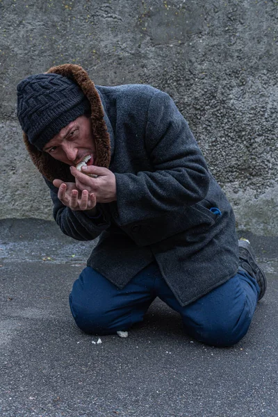 Omul Fără Adăpost Îngenunchează Mănâncă Lăcomie Bucată Pâine Foamete Vagabond — Fotografie, imagine de stoc