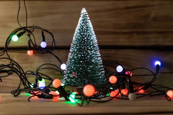 Τεχνητό Χριστουγεννιάτικο Δέντρο Και Γιρλάντα Ξύλινο Φόντο Ρηχό Βάθος Πεδίου — Φωτογραφία Αρχείου