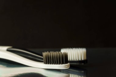 Siyah arka planda siyah beyaz diş fırçaları. Ağız temizliği kavramı