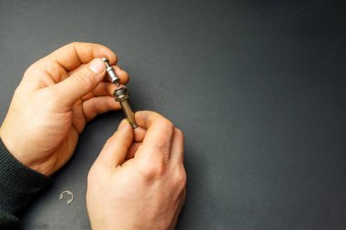 Arabanın gaz enjektörünün pistonu ve silindiri kirli erkek ellerindeydi. Araba benzini ekipmanı servisi. Metin için boş alan.