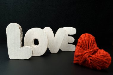 Siyah bir arkaplanda tahta harflerle yazılmış aşk. Sevgililer Günü