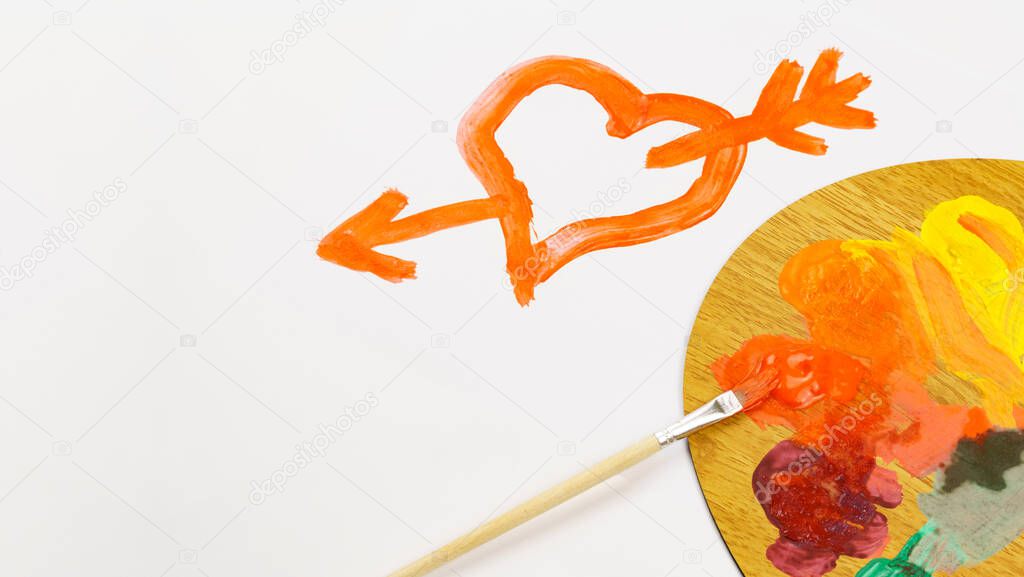 The red heart is painted with paints, and the palette is on a white background with copy space. Drawing Valentine's Day Greeting Card