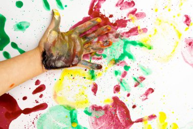 Beyaz arka planda renkli boyalar olan lekeli bir avuç içi. Çocuk elleriyle çiziyor.