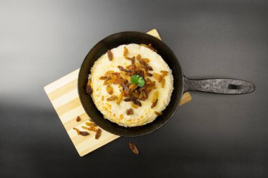 Kuru üzümle süslenmiş gözlemelerle dolu bir tavanın üst görüntüsü. Siyah arkaplan