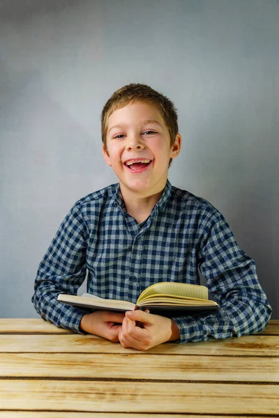 Ein Zahnloser Junge Karierten Hemd Lacht Während Ein Buch Der — Stockfoto