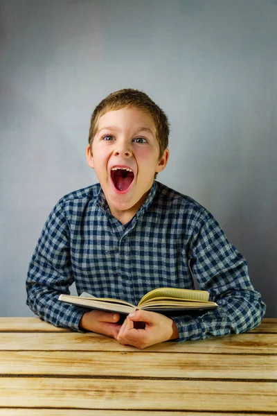 Yawning Child Plaid Shirt Laughs While Holding Book His Hands Royalty Free Stock Photos