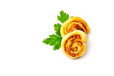 Beyaz arka planda maydanoz yapraklarıyla süslenmiş alupatra patatesli rulo manzarası.