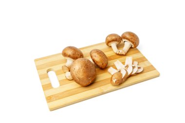 Beyaz arka planda izole edilmiş çizgili kesme tahtasında taze şampiyon mantarları..