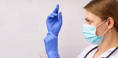 Koruyucu eldiven takan kadın doktor, yüz maskesi ve beyaz arka planda steteskop. Sağlık salgını Coronavirus Covid 19.
