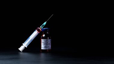 COVID-19 koronavirüs aşısı, aşı şişesi ve koronavirüs tedavisi için şırınga. Tıp konsepti, klinik deneyler, enjeksiyon ve pandemik tedavi