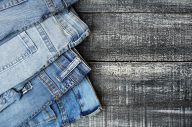 Üst görünüm, siyah beyaz ahşap zemin üzerine istiflenmiş kot pantolon, kopyalama alanı