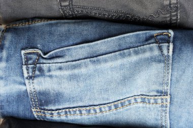 Kot pantolonun en üst görüntüsü. Katlanmış mavi kot pantolonun cebini kapat.