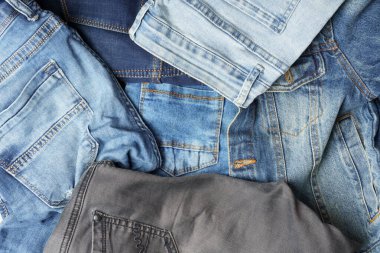 Denim geçmişi. Farklı tonlarda ve desenlerde mavi kot pantolon. Denim moda konsepti.