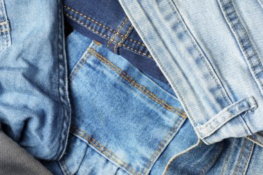 Farklı tonlar ve dokularda kot pantolonların üst görüntüsü. Denim geçmişi. Denim moda konsepti.