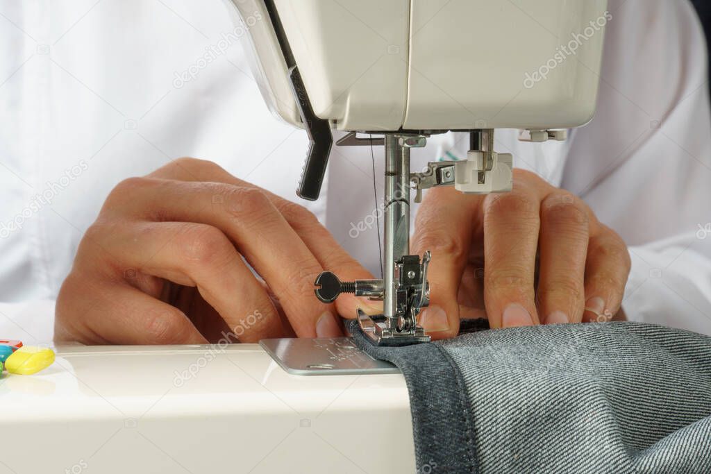 the process of shortening jeans pants on a sewing machine