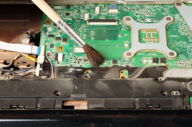 Laptoptan fırçayla toz temizleme. Bilgisayar servisi ve tamir konsepti. yakın plan
