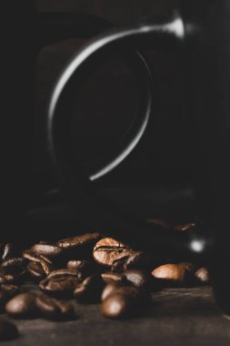 Koyu odunsu arka planda fincan ve kahve taneleri. yakın plan