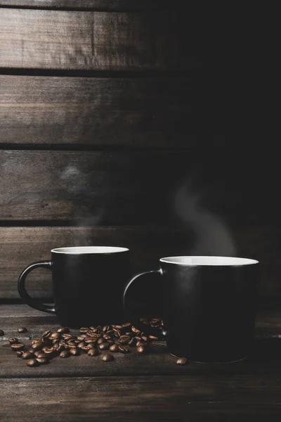 Zwei Tassen Heißen Kaffee Mit Dampf Und Kaffeebohnen Auf Einem — Stockfoto