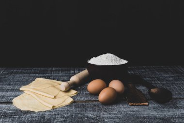 Koyu ahşap arka planda makarna yapmak için malzemeler. Pankart