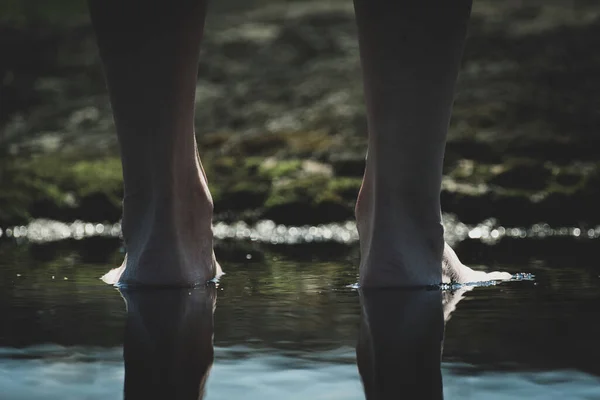 barefoot in a puddle. woman walks barefoot in a puddle outdoors. close-up