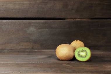 Koyu ahşap arka planda olgun kivi. Kopyalama alanı olan pankart