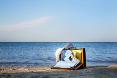 Deniz kıyısındaki retro kahverengi bavul. Metin için boş alan