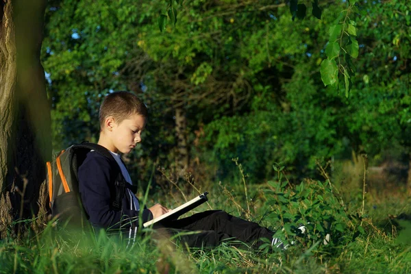 Junge Sitzt Unter Einem Baum Und Liest Ein Buch Kinder — Stockfoto