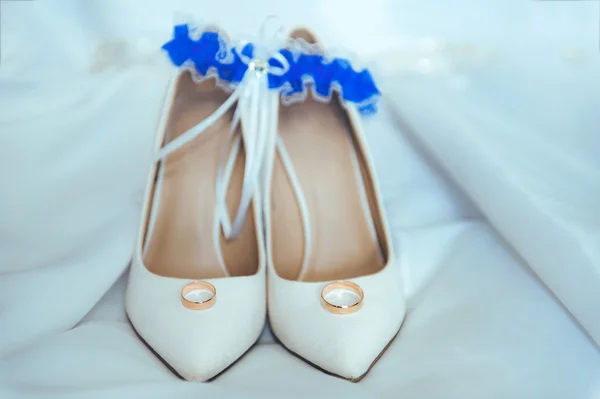 Sapatos de casamento, liga nupcial e anéis dourados — Fotografia de Stock